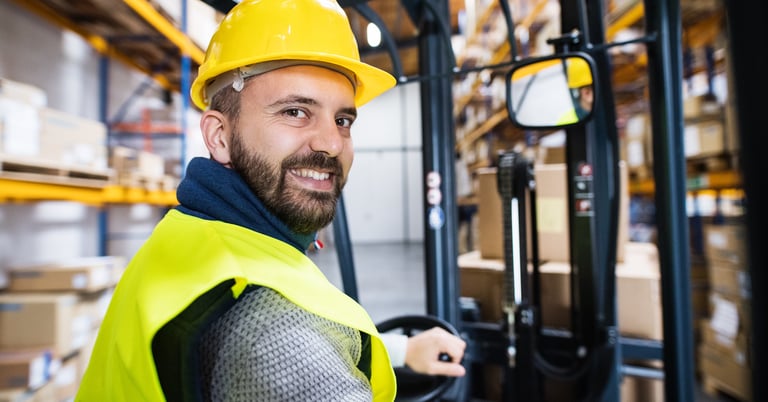 Warehouse worker happy at work on electric truck