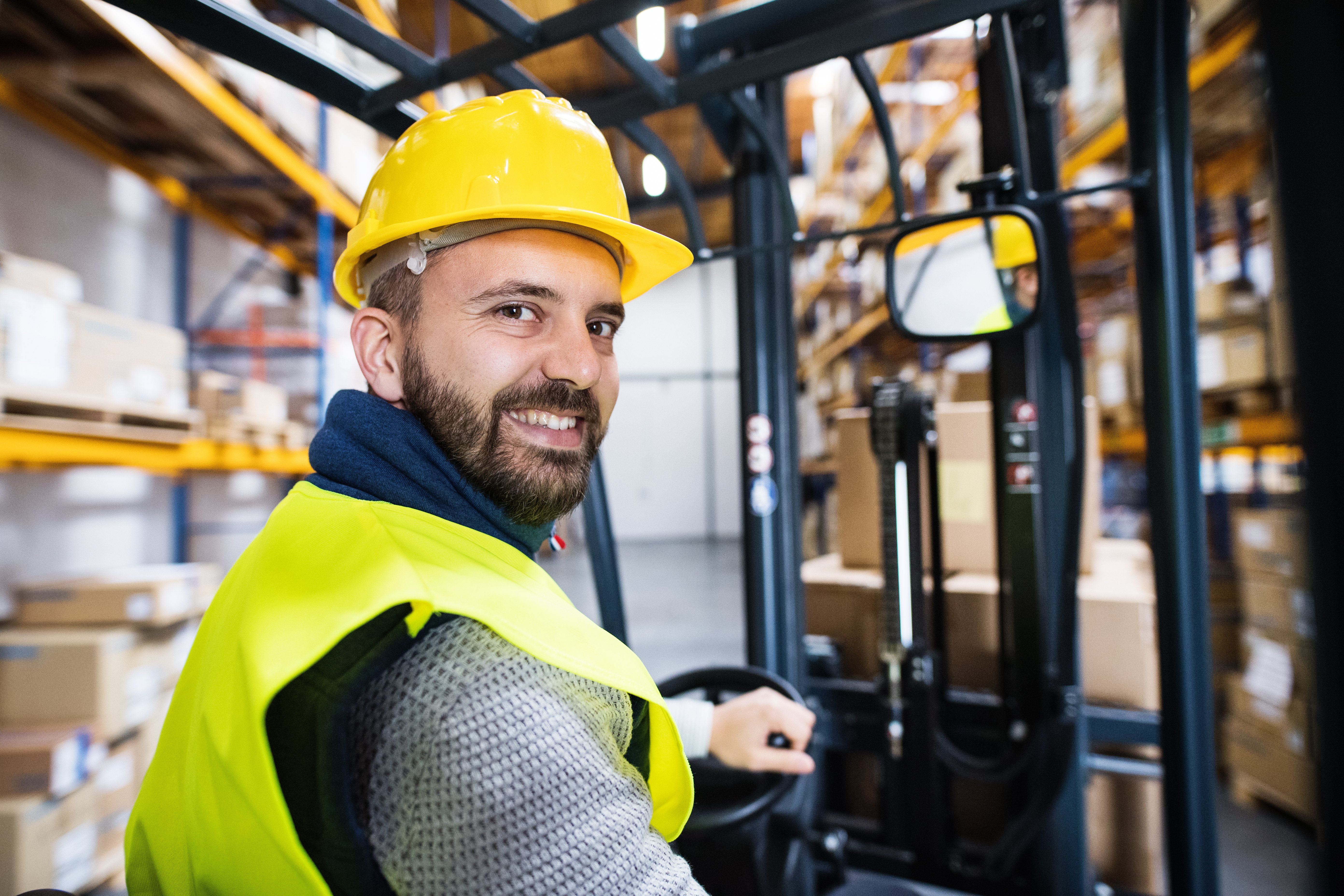 Warehouse worker happy at work on electric truck