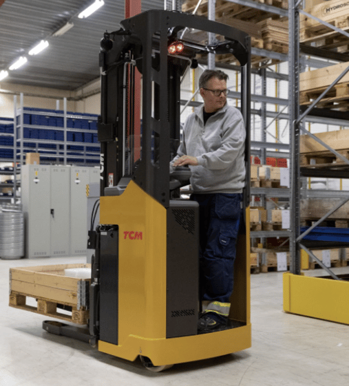 Forklift operator in warehouse TCM SRO stand-in stacker