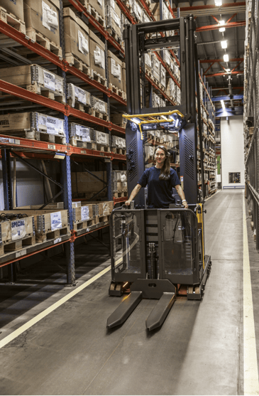Female forklift operator in warehouse order picker
